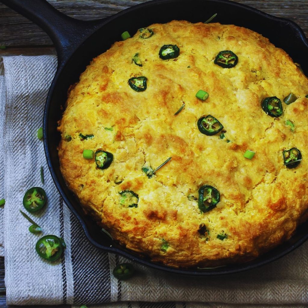 cornbread with jalapenos on top in a cast iron skillet