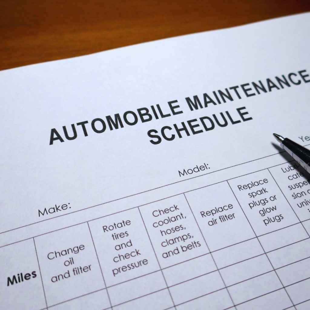 automobile maintenance schedule on paper with a pen on the side