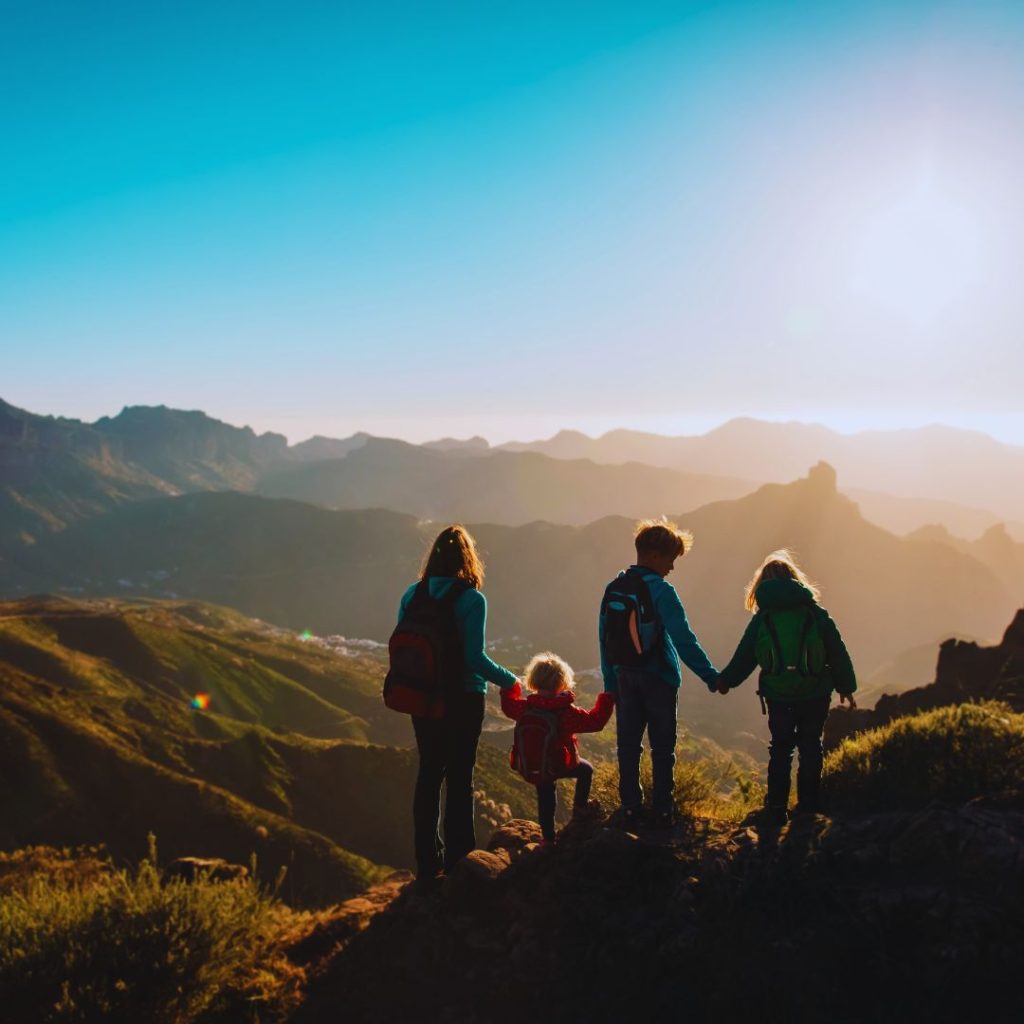 mother and four kids looking out over a valley at sunset