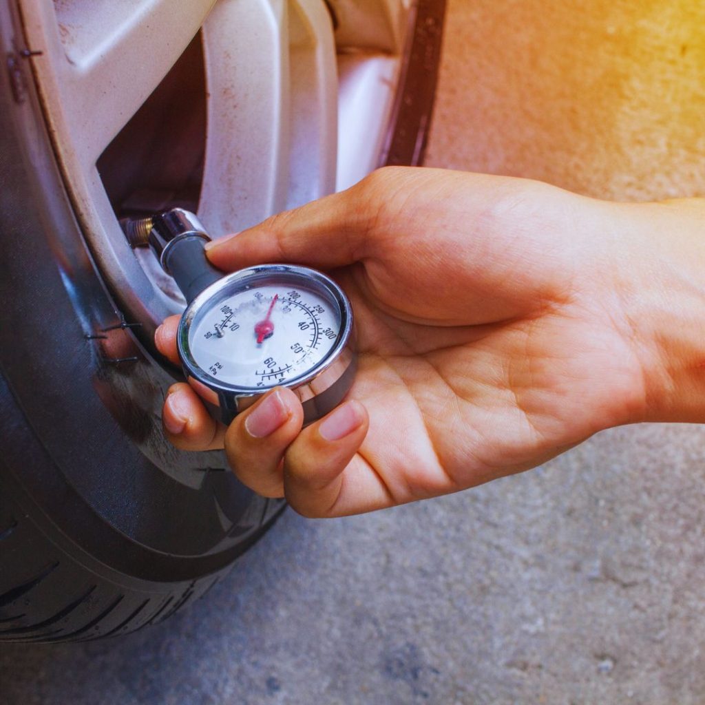 tire pressure gauge being used on the tire