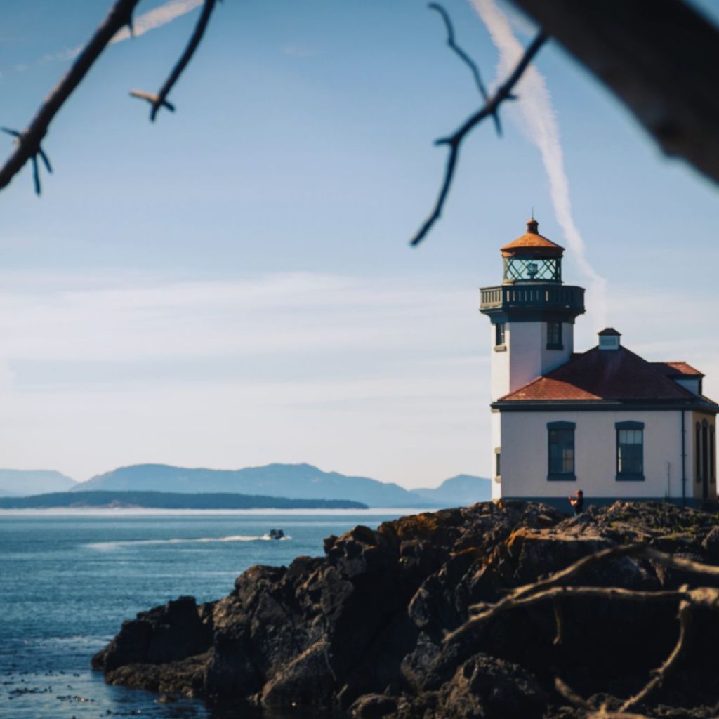 lighthouse overlooking water on a rocky shore